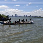 Fisher man are catch the fish in Tonle Sab with the view of city Phnom Penh background.